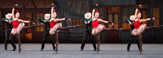 New York CIty Ballet ballerinas in bright red tutus dance in front of men in cowboy hats and black cowboy clothes